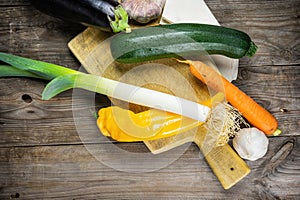 Fresh vegetables ready for cooking shot on rustic wooden table.