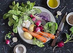 Fresh vegetables - red cabbage, radishes, carrots, potatoes, garlic, onions, olive oil and spices on a dark stone background. Hea
