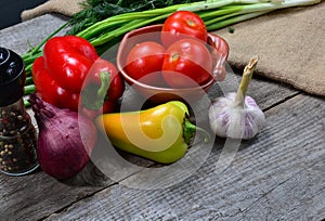 fresh vegetables red peppers, garlic, green onions, tomatoes, wooden table background