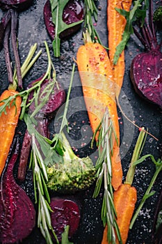 Fresh vegetables for roasting on rustic dark background