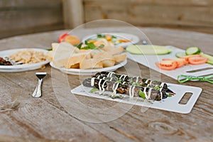 Fresh vegetables with salad and grilled sausages on a wooden table background