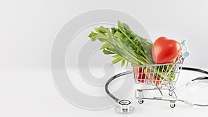 Fresh vegetables in a shopping cart with heart and stethoscope