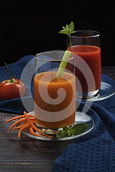 Fresh vegetables smoothie carrots, celery and tomatoes with herbs and mint. On a dark background