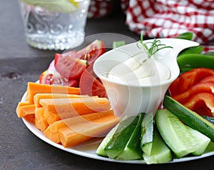 Fresh vegetables snack - carrots, cucumbers and tomatoes with dip
