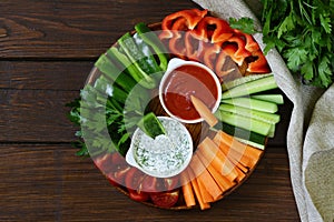 Fresh vegetables snack - carrots, cucumbers and tomatoes with dip