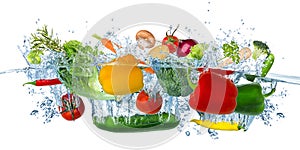 Fresh vegetables splashing into blue clear water splash healthy food diet freshness concept isolated white background photo