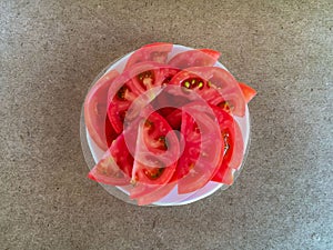 Fresh vegetables. Tomato on a white plate.