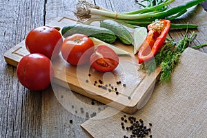 fresh vegetables tomatoes, cucumber, chili pepper, dill on wooden background.