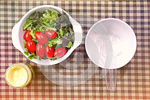 Tomato vegetables in a bowl of salad dressings and bowls on a plate of food.