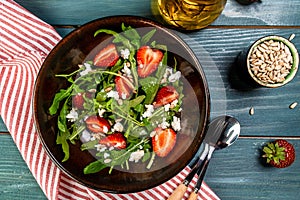 Fresh vegetarian diet salad with strawberries, aragula and cheese. Food recipe background. Close up. top view