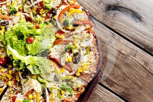 Fresh vegetarian pizza on wooden table background