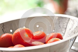 Fresh, Vibrant Roma Tomatoes in Colander with Wate