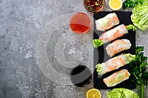 Fresh Vietnamese, Asian, Chinese food frame on grey concrete background. Spring rolls rice paper, lettuce, salad