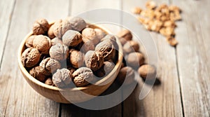 Fresh walnut kernels and whole walnuts in a bowl on rustic old wooden table. photo