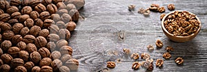 Fresh walnut kernels and whole walnuts in a bowl on rustic old wooden table. photo