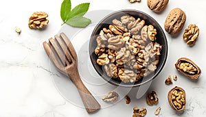Fresh walnuts in bowl and nutcracker on gray table, flat lay