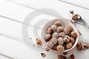 Fresh walnuts bowl on white wooden background