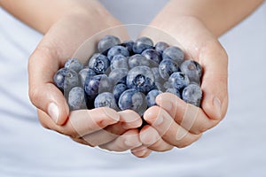 Fresh washed blueberries in female teen hands