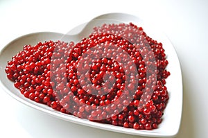 Fresh washed red currants berries in a heart shaped bowl