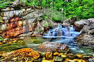 Fresh water cascading over large rocks in a small stream HDR.