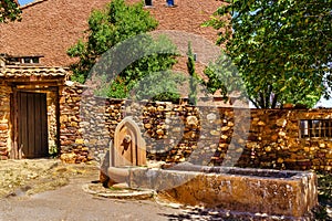 fresh water fountain at the entrance of an old stone house. Spain photo