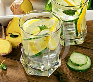 Fresh water with lemon, mint and cucumber on a wooden backgrou