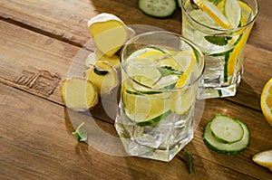 Fresh water with lemon, mint , ginger and cucumber on a wooden