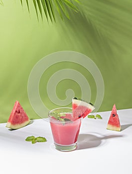 Fresh water melon juice and watermelon slice on green background. summer drink