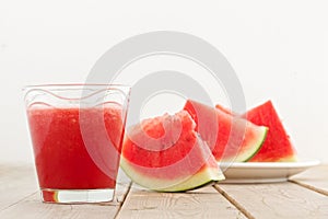 Fresh watermelon blending in glass on wood table