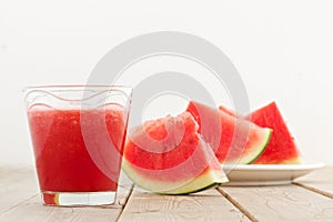 Fresh watermelon blending in glass on wood table photo