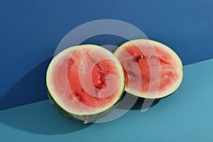 Fresh watermelon halves on two tone background