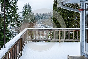 Fresh wet snow on a cedar deck, view of snow-covered neighborhood