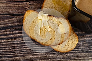 Fresh wheat bread toast with butter on a wooden background. Close up