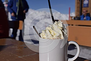 Fresh whipped cream and hot chocolate on snowy mountain photo