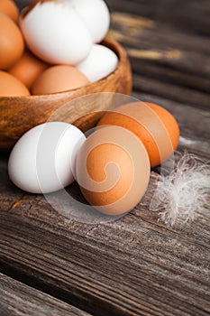 Fresh white and brown chicken eggs on wooden background