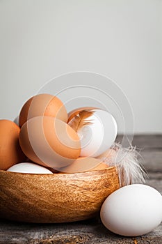 Fresh white and brown chicken eggs on wooden background