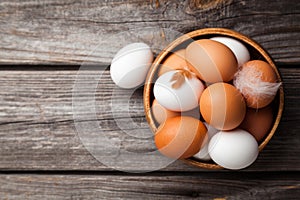 Fresh white and brown chicken eggs on wooden background