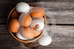 Fresh white and brown chicken eggs on wooden background