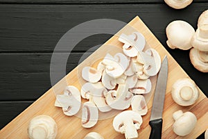 Fresh white champignon mushrooms on cutting board. Space for text