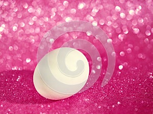 Fresh white egg over pink bokeh background