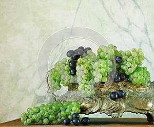 Fresh white grapes decorated on rustic light shabby chic table in a vintage tray