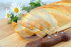 Fresh white loaf of bread with a knife