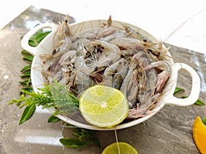 Fresh White Prawns decorated in a white bowl with herbs and fruits.Selective focus