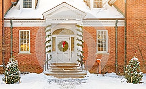 fresh white Winter snow on entrance to Stockbridge Library decorated for Christmas