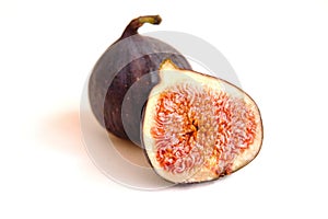 Fresh whole and bisected figs on white backdrop