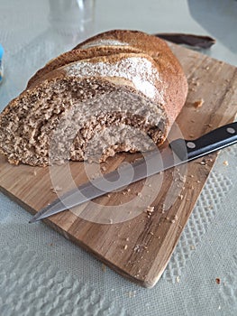 Fresh whole bread on chopping board