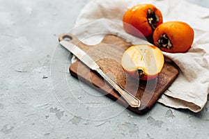 Fresh whole persimmon on wooden background