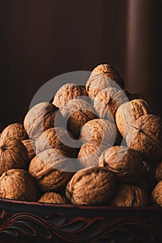 Fresh whole walnuts in shell in a plate. Vertical photo