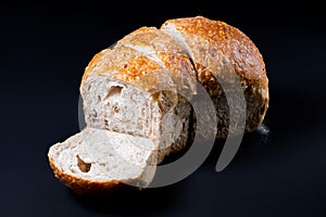 Fresh whole wheat bread with a coffee mug on black background.