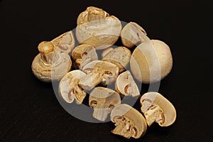 Fresh whole white button mushrooms, or agaricus on black background